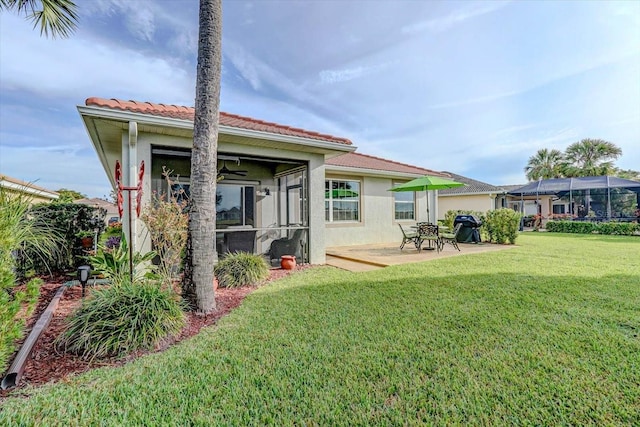 rear view of house with a patio and a lawn