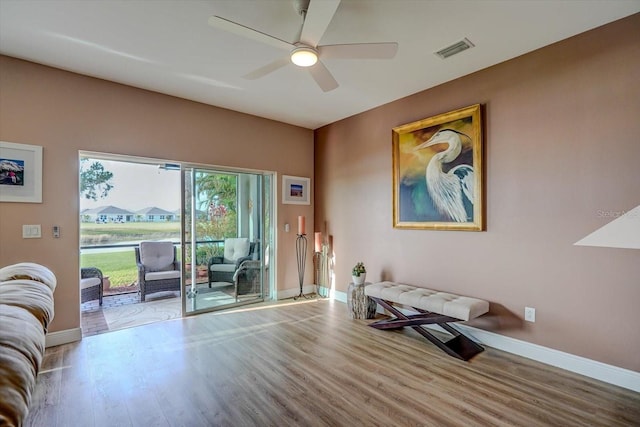 sitting room with ceiling fan and light wood-type flooring