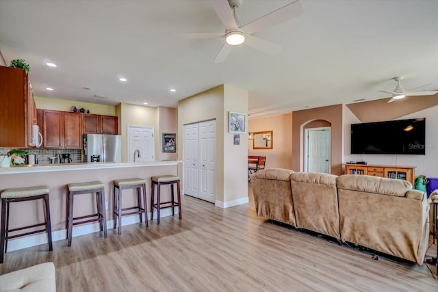 living room with ceiling fan and light wood-type flooring