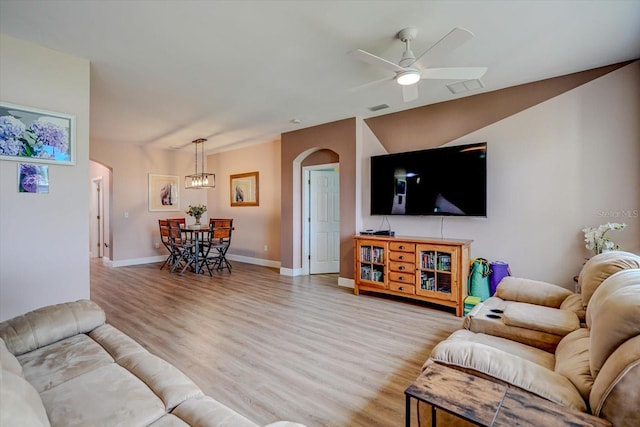 living room with light hardwood / wood-style floors, ceiling fan, and lofted ceiling