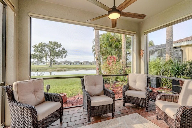 sunroom with a water view and ceiling fan