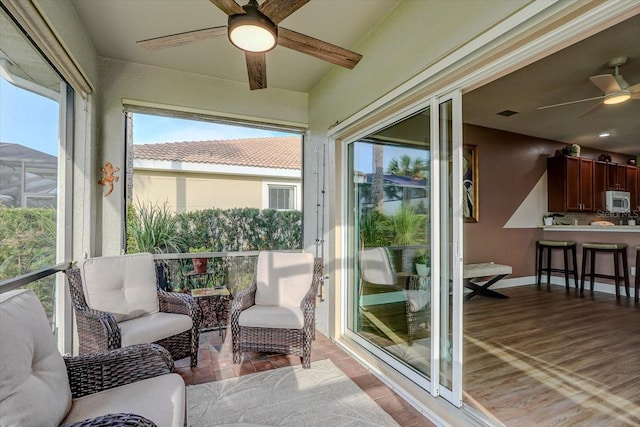 sunroom / solarium featuring ceiling fan