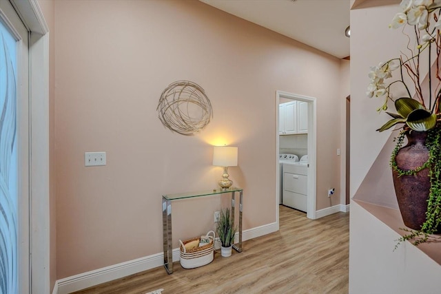 corridor featuring washing machine and dryer and light hardwood / wood-style flooring