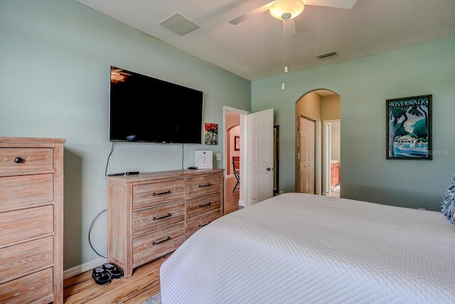 bedroom featuring ensuite bath, light hardwood / wood-style flooring, and ceiling fan