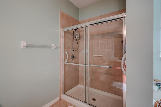 bathroom with tile patterned flooring and a shower with shower door