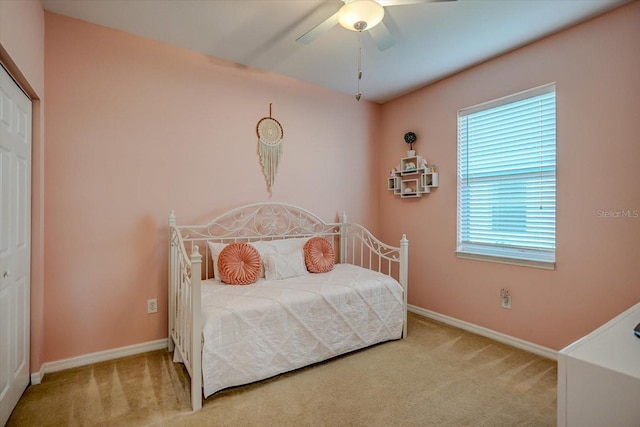 carpeted bedroom with ceiling fan and a closet