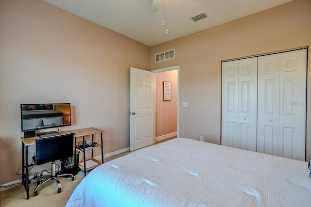 bedroom with ceiling fan, light carpet, and a closet