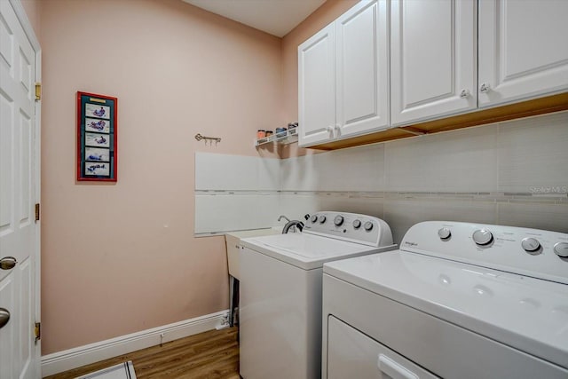 washroom with wood-type flooring, cabinets, and independent washer and dryer