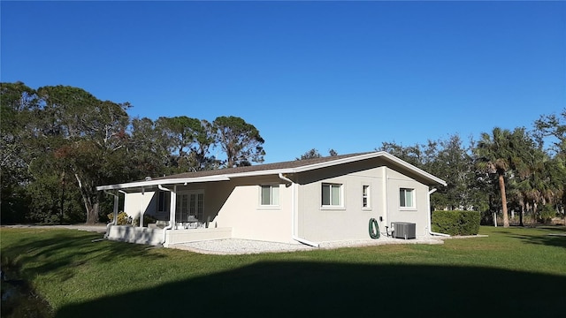 back of house with a yard and central AC