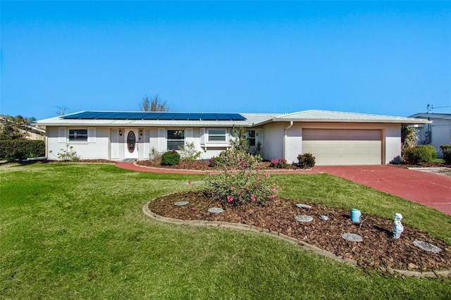 single story home featuring solar panels, a garage, and a front yard