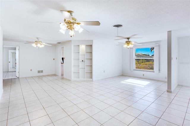 unfurnished living room featuring built in shelves, a textured ceiling, and light tile patterned flooring