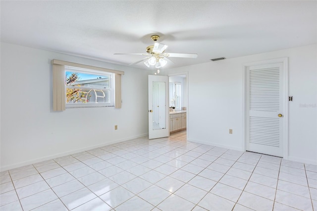 tiled empty room featuring ceiling fan