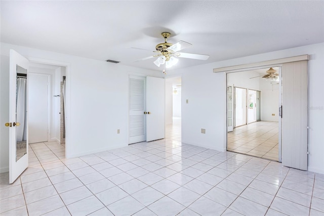 spare room featuring ceiling fan and light tile patterned floors