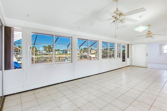 unfurnished sunroom featuring ceiling fan and a healthy amount of sunlight