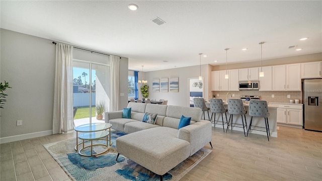 living room with a water view and an inviting chandelier