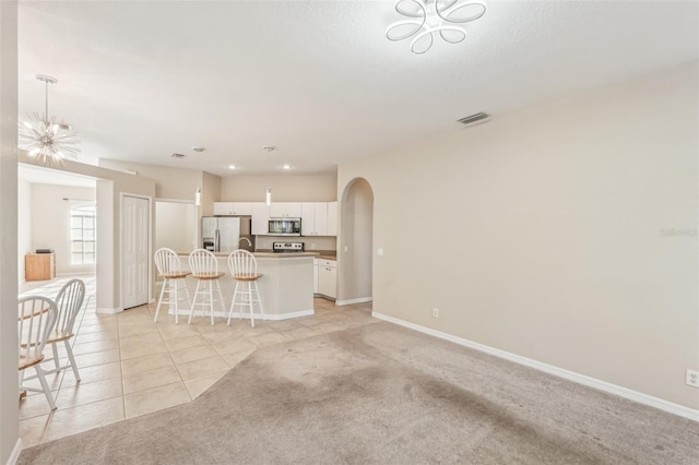 unfurnished living room with light colored carpet and an inviting chandelier