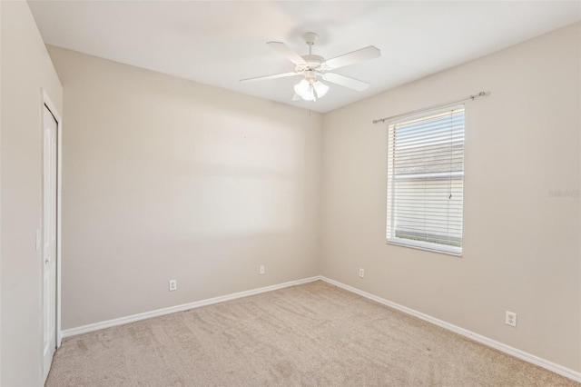 carpeted spare room featuring ceiling fan