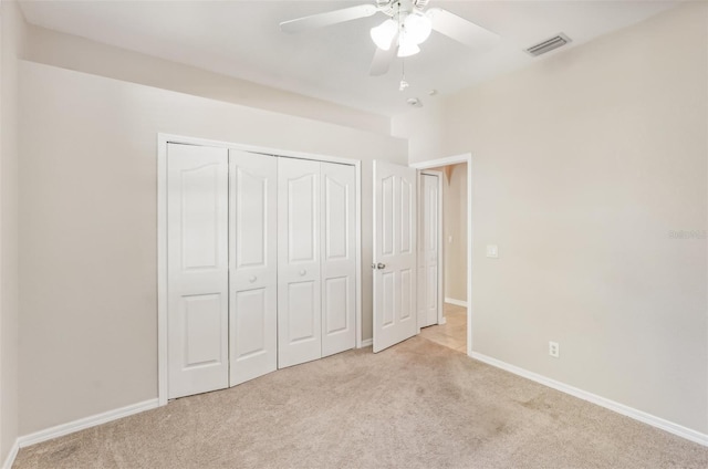 unfurnished bedroom featuring ceiling fan, a closet, and light colored carpet