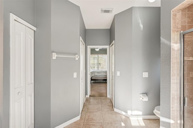 bathroom featuring tile patterned floors, toilet, and an enclosed shower