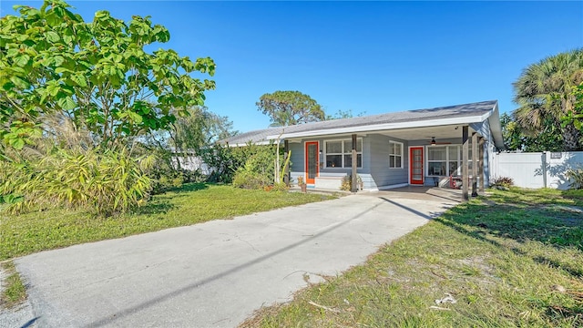 view of front of house with a carport, ceiling fan, covered porch, and a front yard