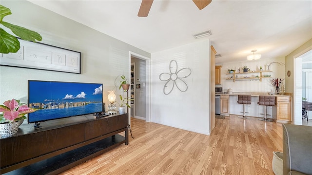 living room with ceiling fan and light wood-type flooring