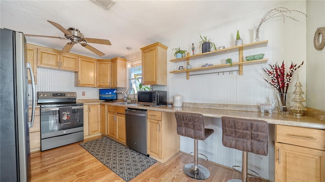 kitchen with ceiling fan, sink, light brown cabinets, stainless steel appliances, and light hardwood / wood-style floors