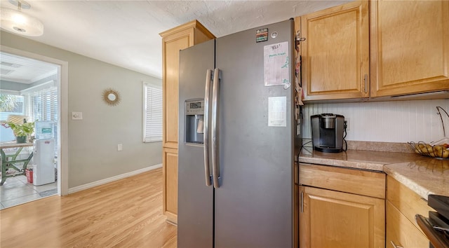 kitchen with decorative backsplash, stainless steel fridge with ice dispenser, light hardwood / wood-style flooring, and light brown cabinetry