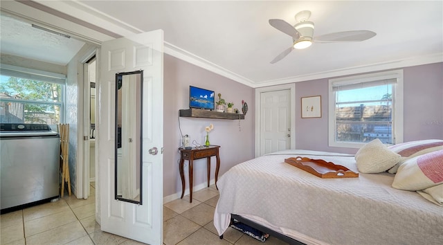 tiled bedroom featuring ceiling fan, washer / dryer, ornamental molding, and multiple windows