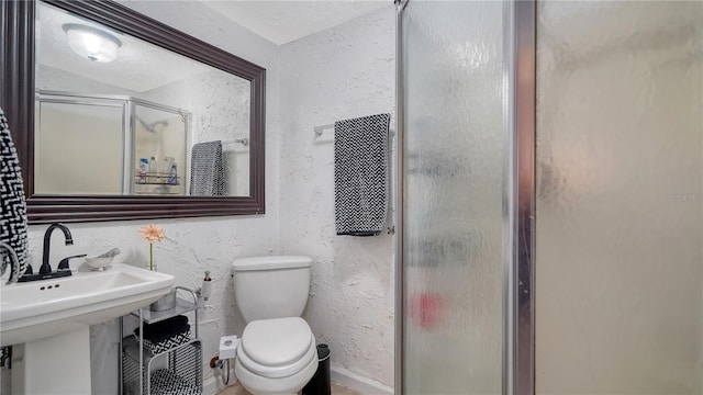 bathroom with toilet, an enclosed shower, and sink