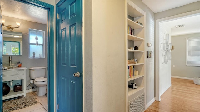 bathroom with hardwood / wood-style floors, a healthy amount of sunlight, and toilet