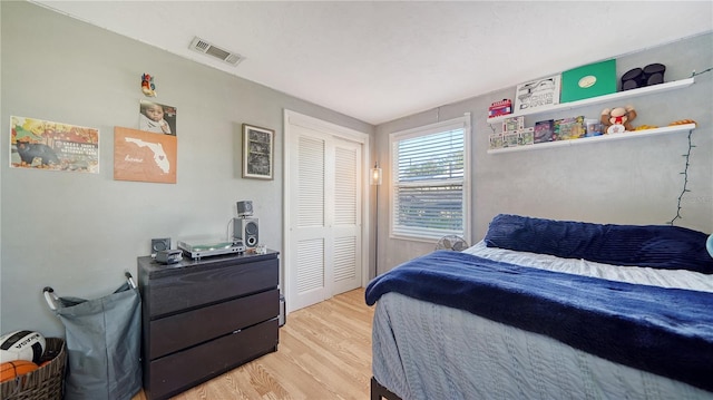 bedroom with light wood-type flooring and a closet