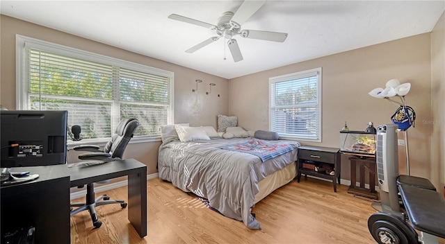 bedroom featuring multiple windows, ceiling fan, and light wood-type flooring