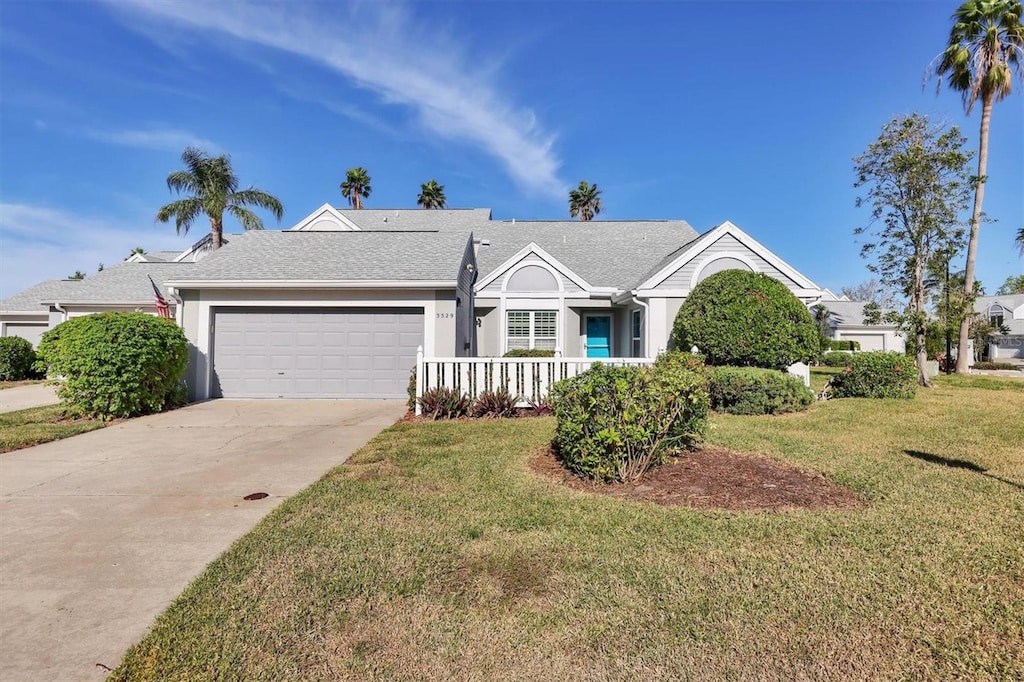 single story home featuring a porch, a front yard, and a garage