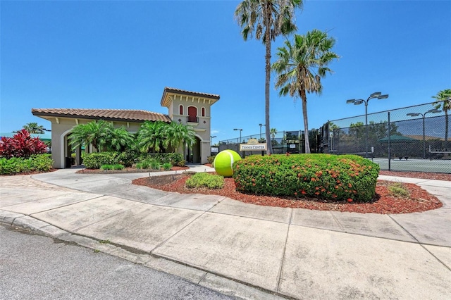 view of home's community with tennis court