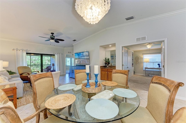 tiled dining area with crown molding, ceiling fan with notable chandelier, and vaulted ceiling