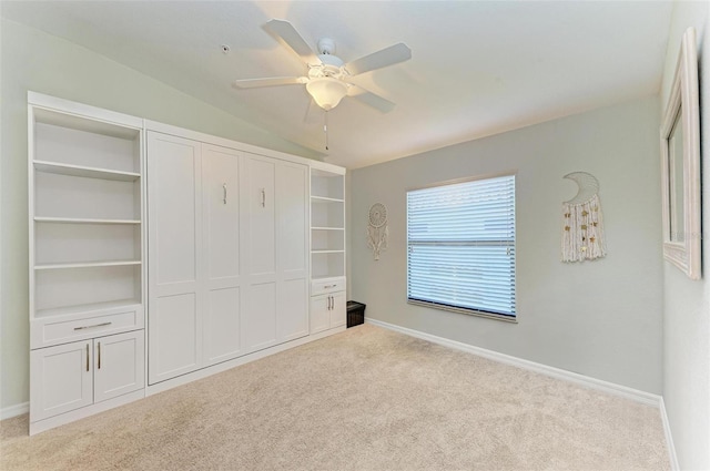 unfurnished bedroom featuring vaulted ceiling, light colored carpet, a closet, and ceiling fan