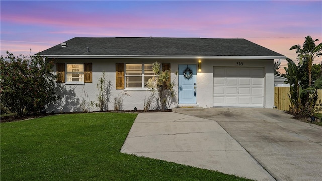 single story home featuring a yard and a garage