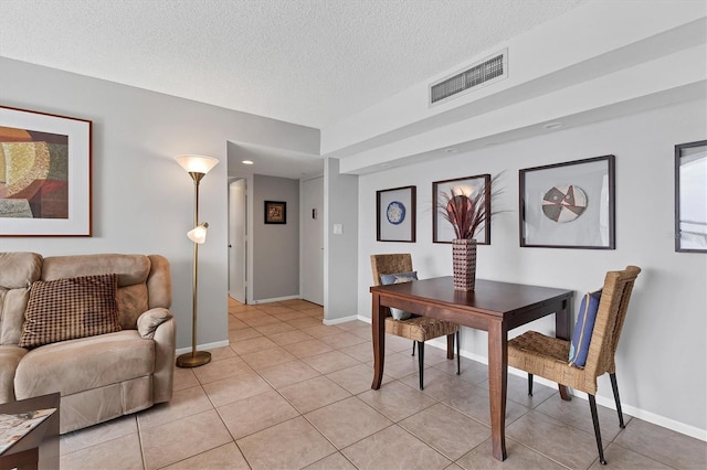 tiled dining room with a textured ceiling