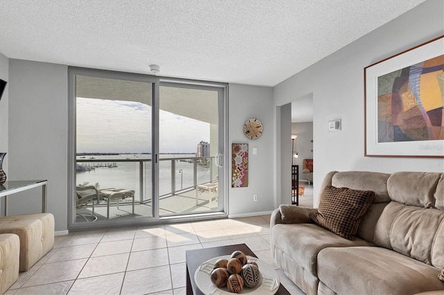 living room with floor to ceiling windows, light tile patterned flooring, and a textured ceiling