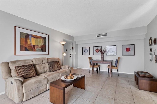 tiled living room featuring a textured ceiling