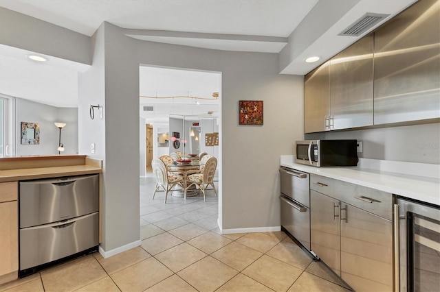 kitchen featuring light tile patterned flooring, stainless steel appliances, and beverage cooler