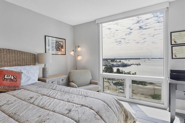 bedroom featuring a water view and a textured ceiling