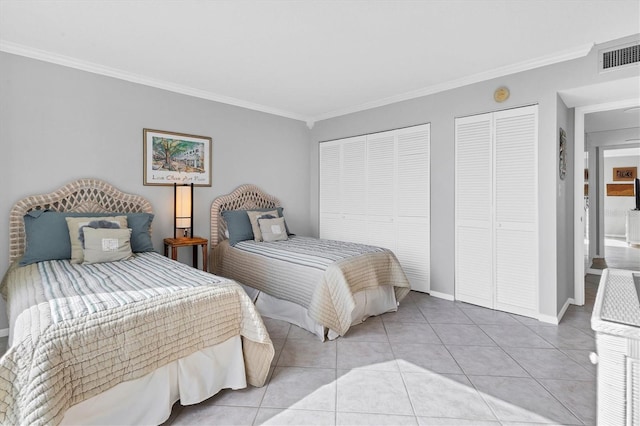 tiled bedroom featuring two closets and ornamental molding