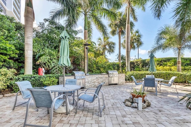 view of patio with exterior kitchen and a grill