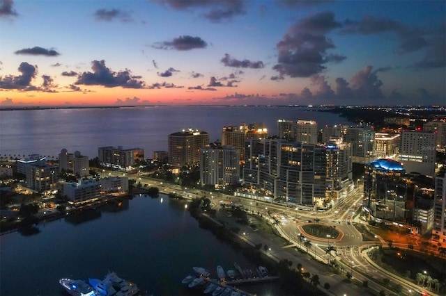 aerial view at dusk featuring a water view