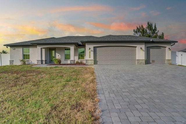 prairie-style house featuring a garage and a lawn