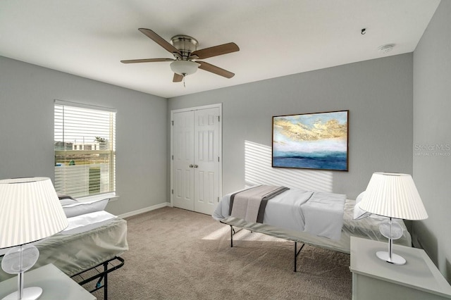 carpeted bedroom with ceiling fan and a closet