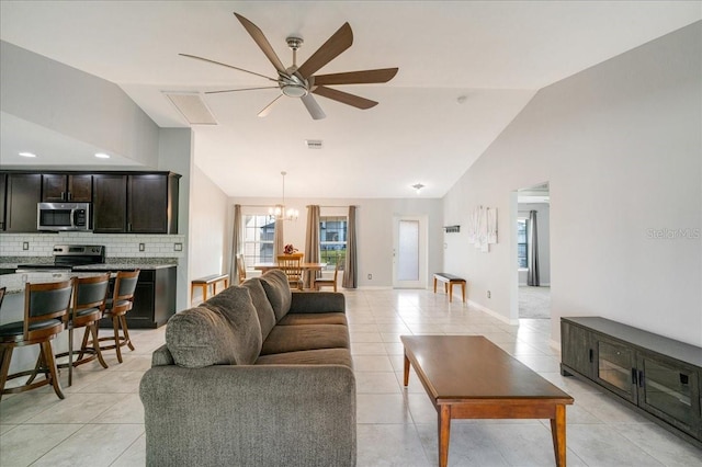 living room featuring light tile patterned floors, vaulted ceiling, and ceiling fan with notable chandelier