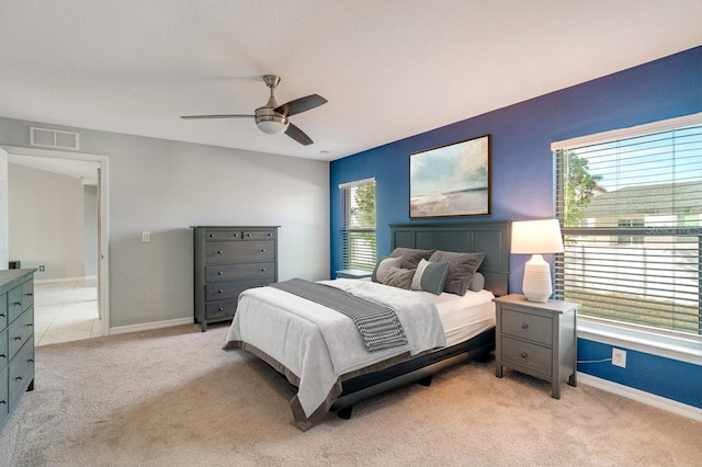 carpeted bedroom with ceiling fan and multiple windows