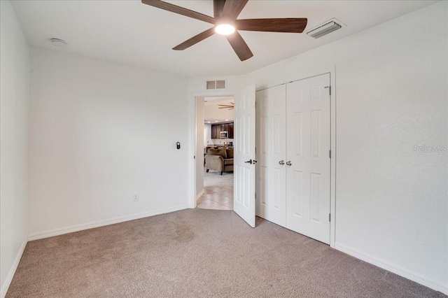 unfurnished bedroom featuring ceiling fan, carpet, and a closet